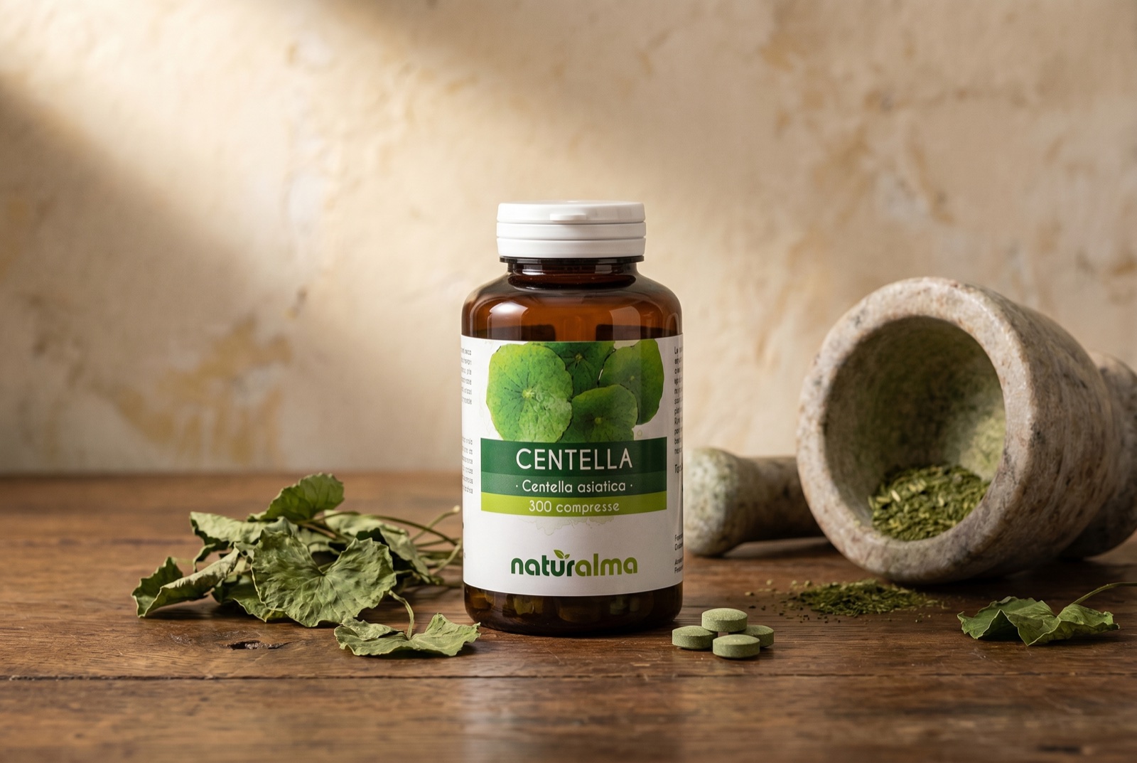 Centella asiatica — still life with round, fan-shaped leaves and a Naturalma jar of tablets