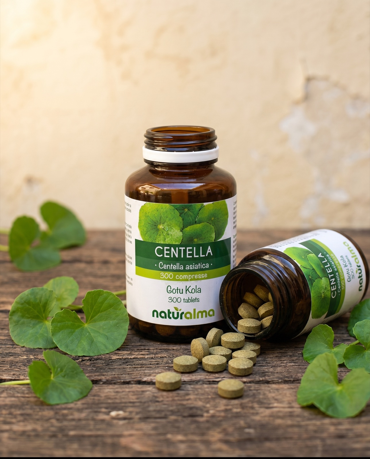 Centella asiatica — compresse che escono dal barattolo Naturalma, accanto a foglie di centella